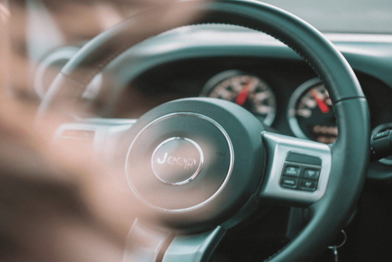 A blurry image of the steering wheel and dashboard.