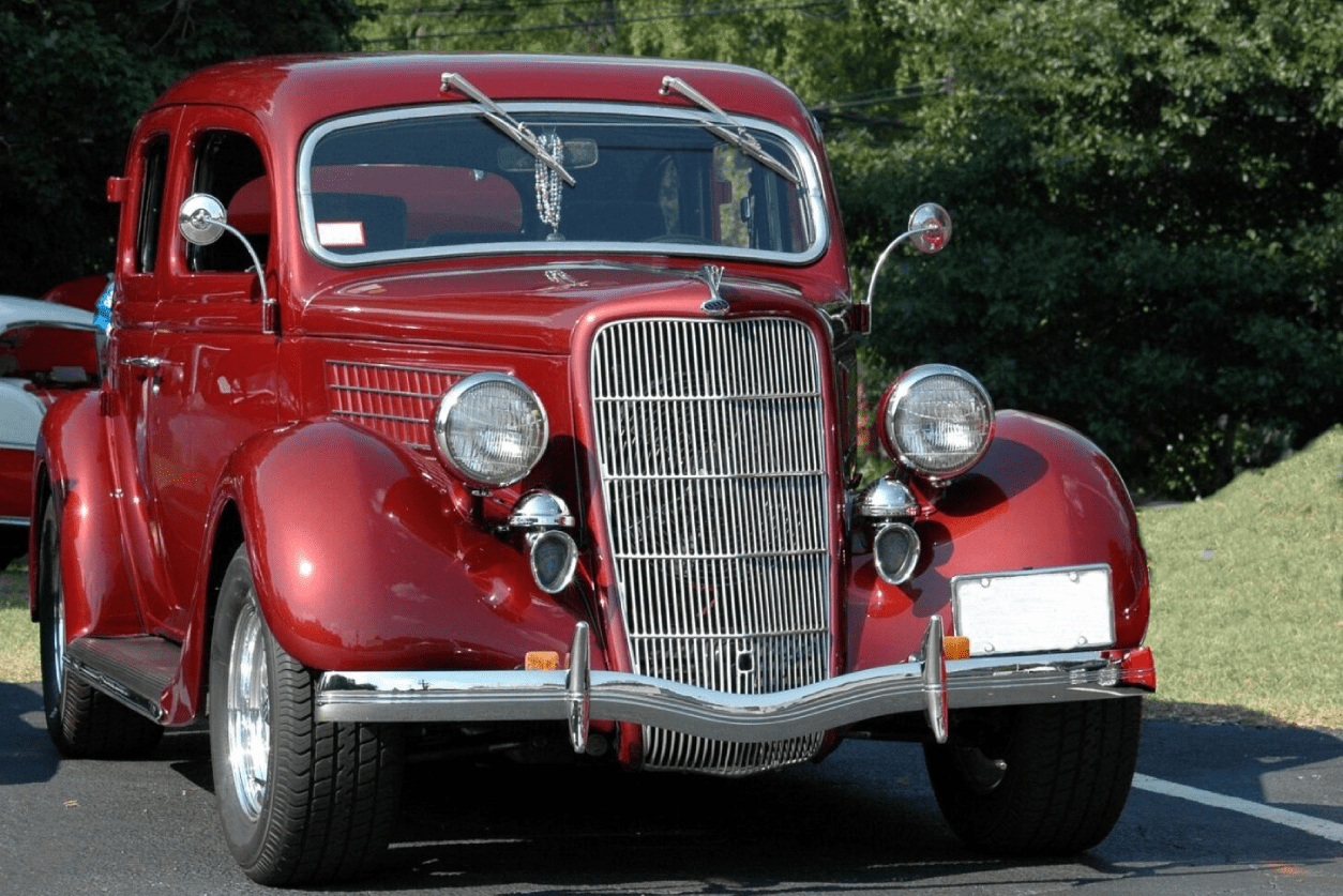 A red car is parked on the side of the road.