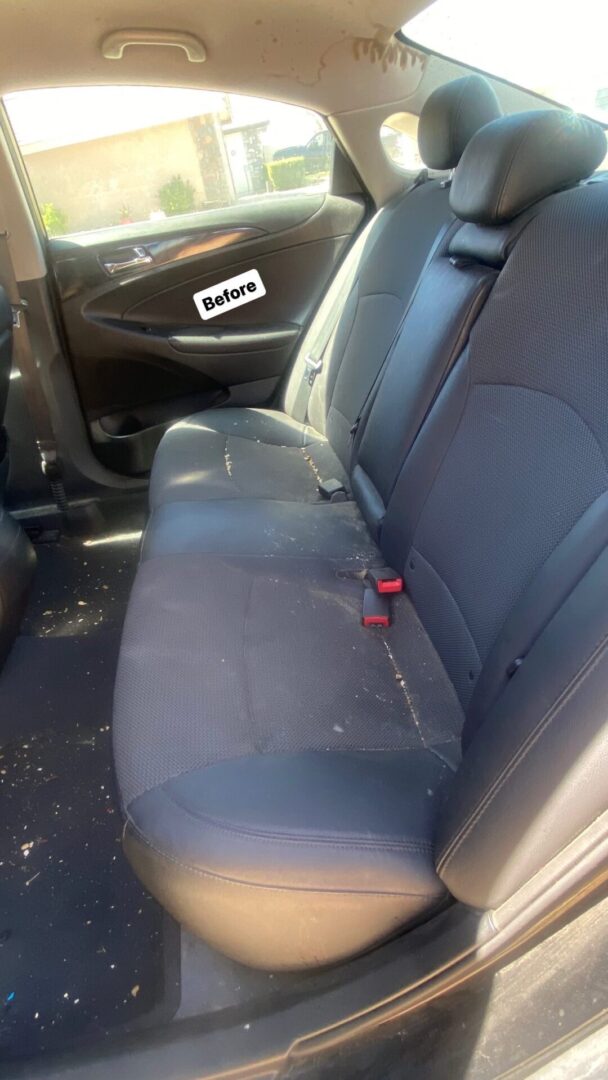 A back seat of a car that needs cleaning.