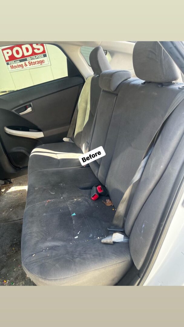 A back seat of a car that needs cleaning.